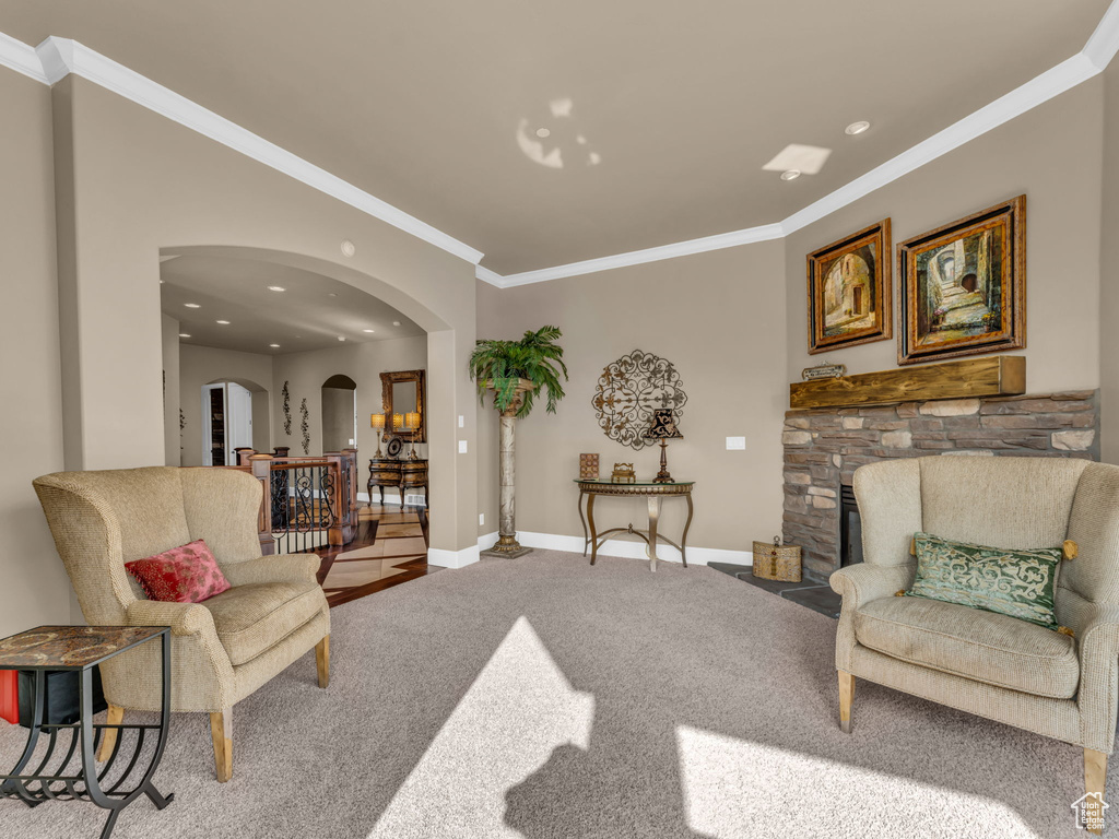Living area with arched walkways, carpet floors, crown molding, baseboards, and recessed lighting