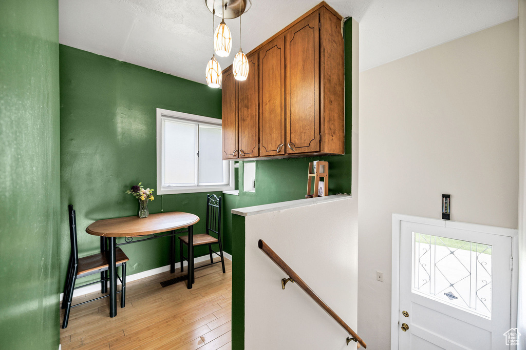 Kitchen featuring light wood finished floors, brown cabinets, plenty of natural light, and pendant lighting