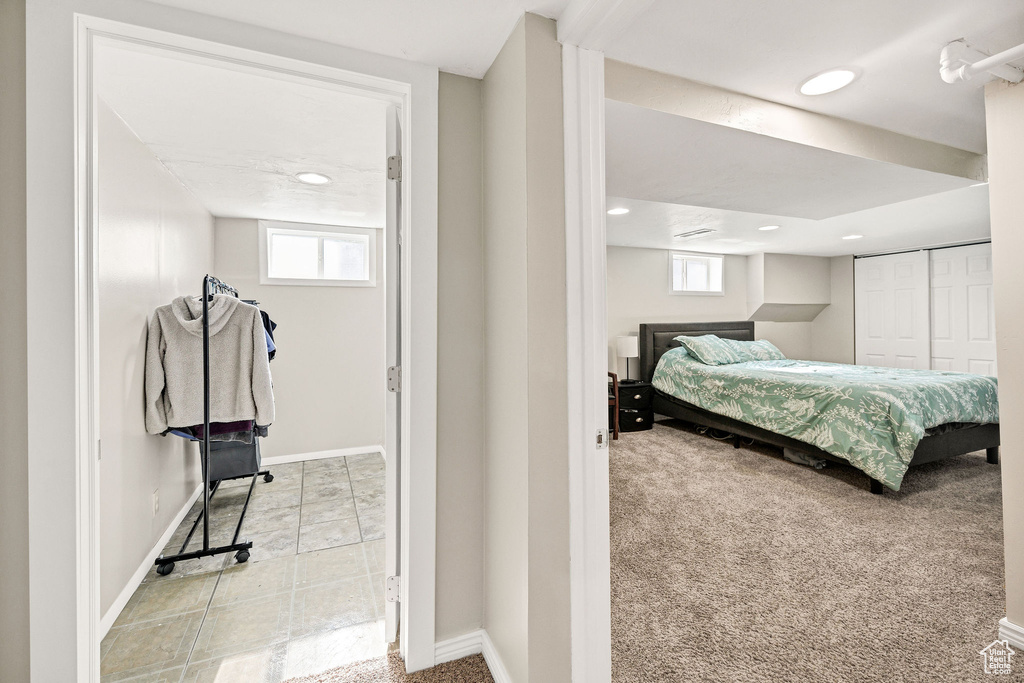 Bedroom with baseboards, multiple windows, recessed lighting, light carpet, and a closet