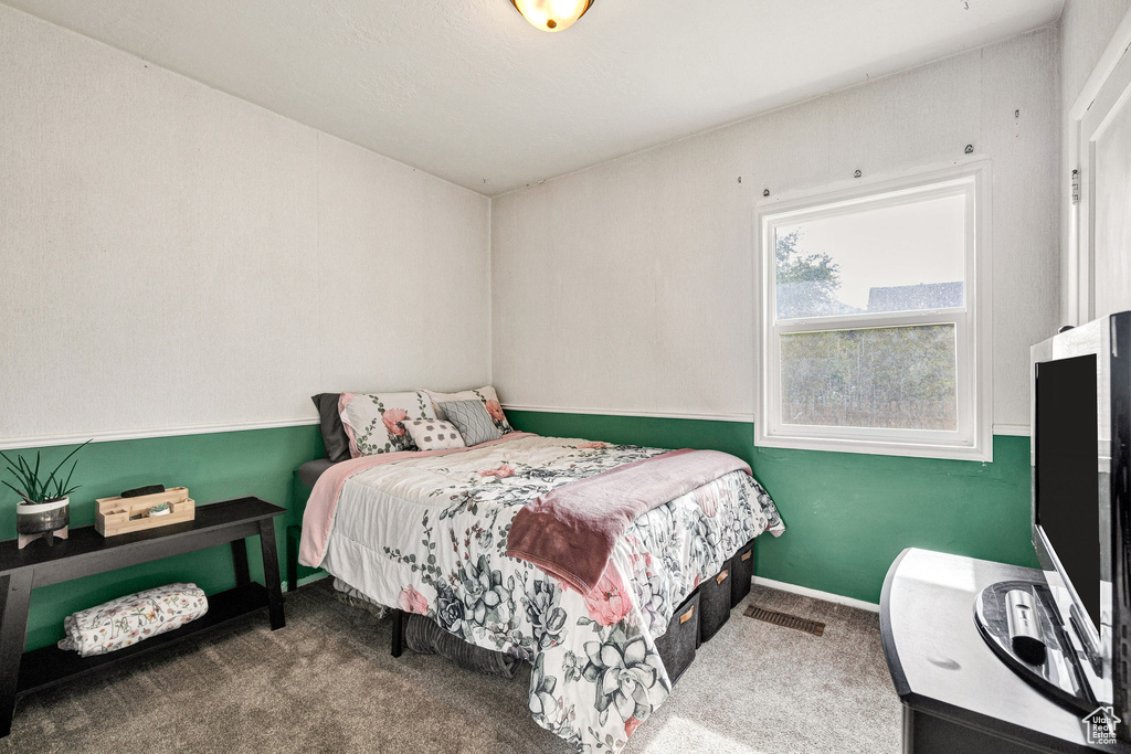 Bedroom featuring carpet and baseboards