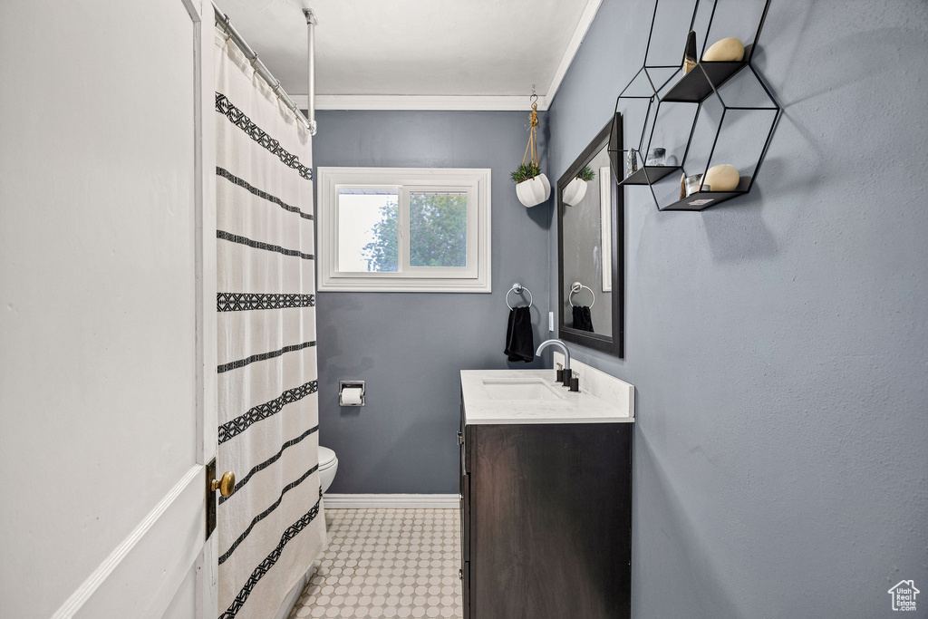 Bathroom featuring tile patterned floors, vanity, ornamental molding, and a shower with curtain