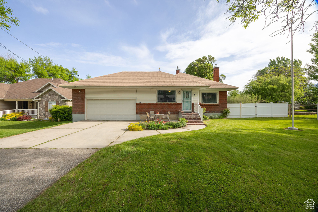 View of front of property featuring a garage, a chimney, brick siding, concrete driveway, and entry steps