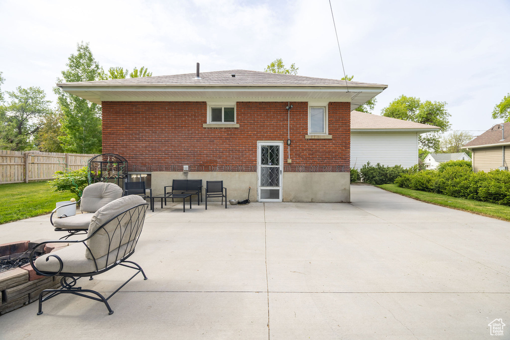 Back of property featuring a patio, fence, and brick siding