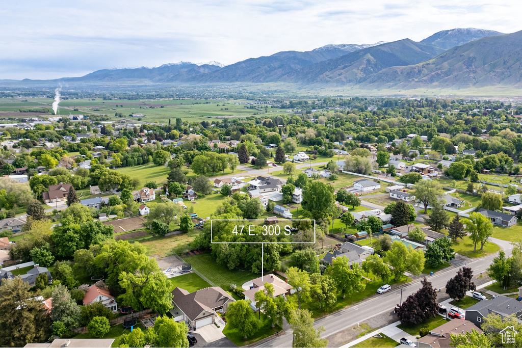 Aerial perspective of suburban area with property parcel outlined and mountains