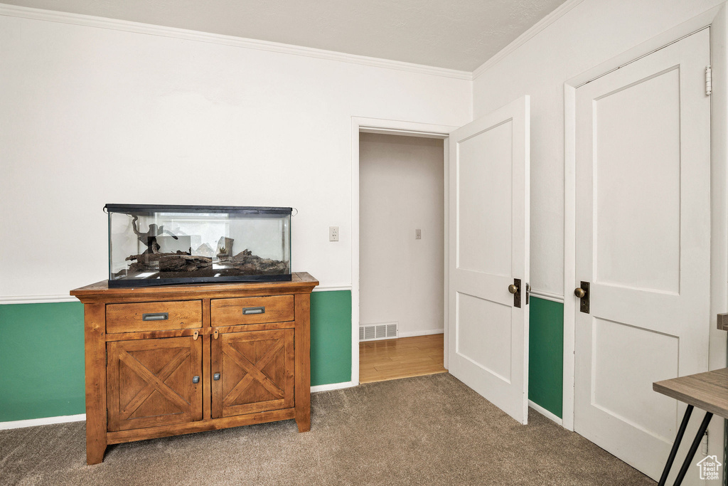 Bedroom featuring crown molding, carpet floors, and baseboards