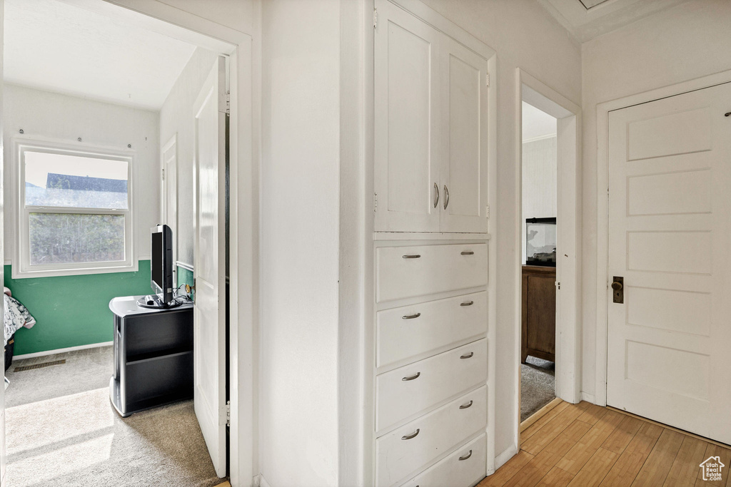 Hallway featuring light wood finished floors and baseboards