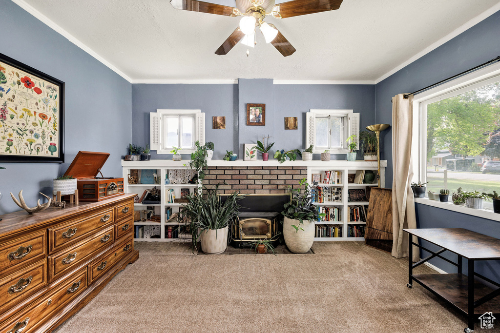 Sitting room with carpet, a ceiling fan, and ornamental molding