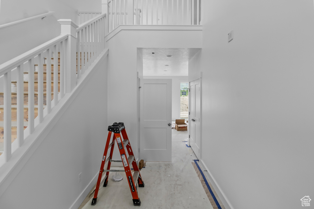 Stairway featuring baseboards and a towering ceiling