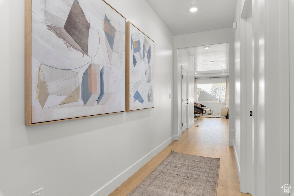Hall featuring light wood finished floors, recessed lighting, and baseboards