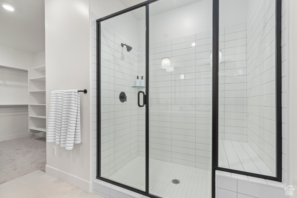 Bathroom featuring a shower stall and baseboards