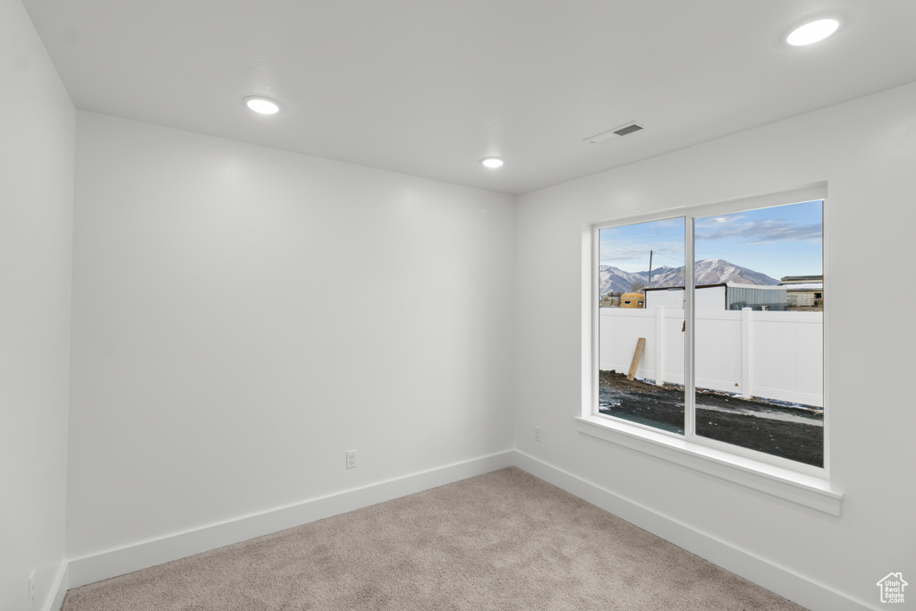 Carpeted spare room with baseboards and recessed lighting