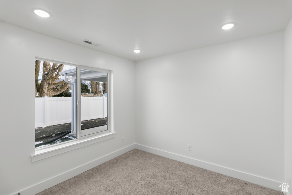 Empty room featuring light colored carpet, recessed lighting, and baseboards