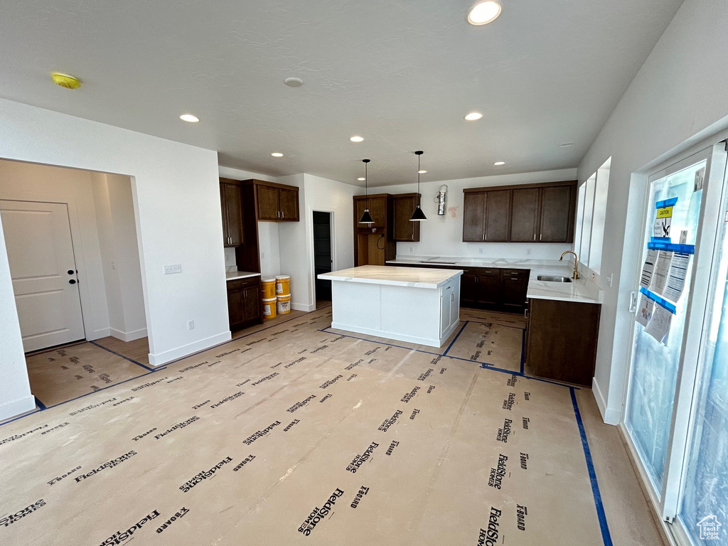 Kitchen featuring dark brown cabinets, healthy amount of natural light, recessed lighting, and a kitchen island