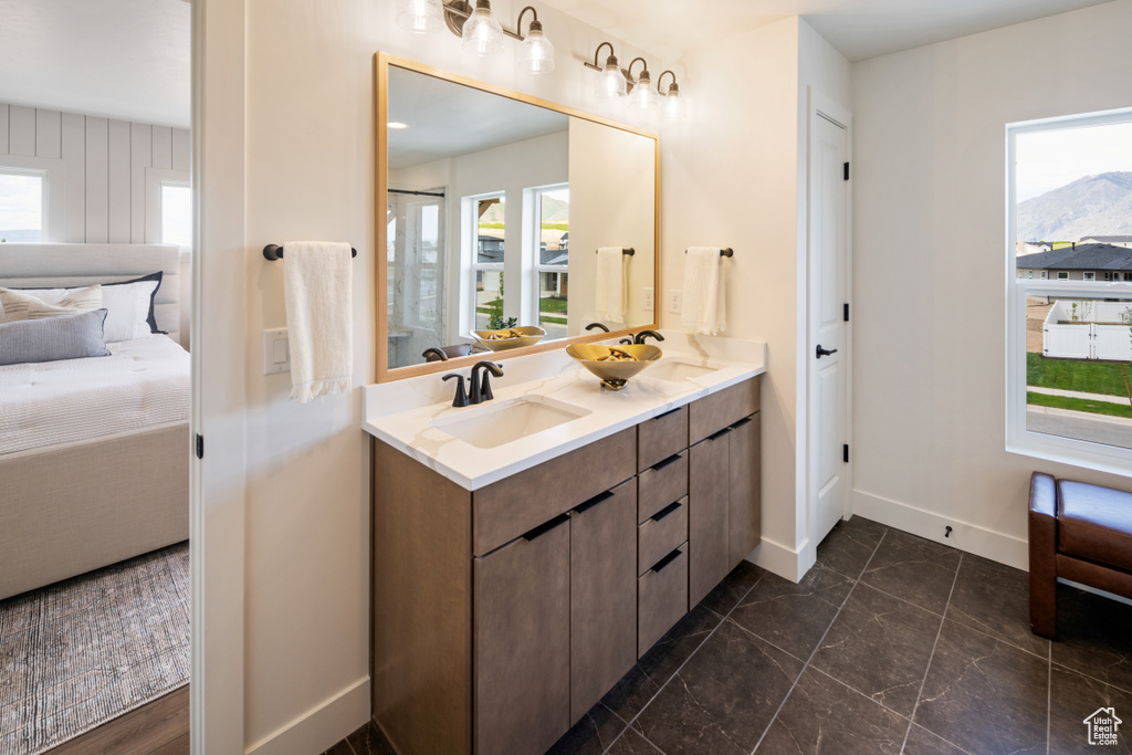Bathroom with ensuite bath, baseboards, double vanity, and marble finish floors