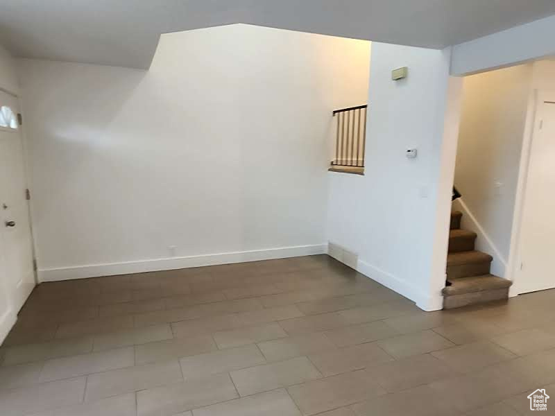 Spare room with stairway and baseboards