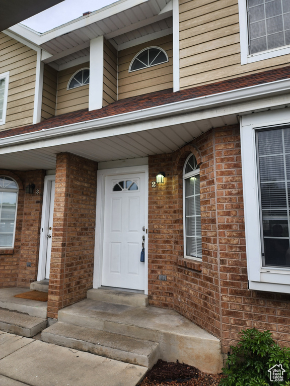 View of exterior entry featuring brick siding