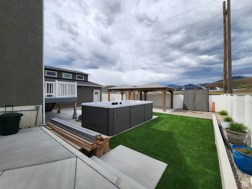 View of yard featuring a gazebo, a patio area, a storage shed, an outdoor structure, and a hot tub