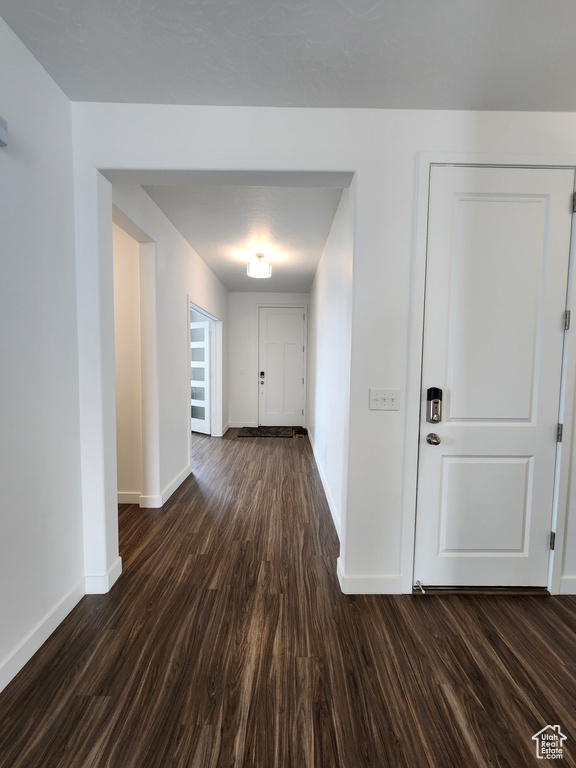 Hall featuring baseboards and dark wood finished floors