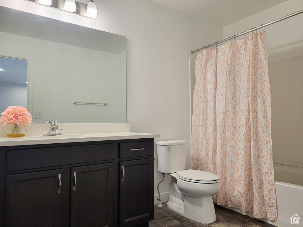 Bathroom featuring toilet, vanity, and shower / bathtub combination with curtain