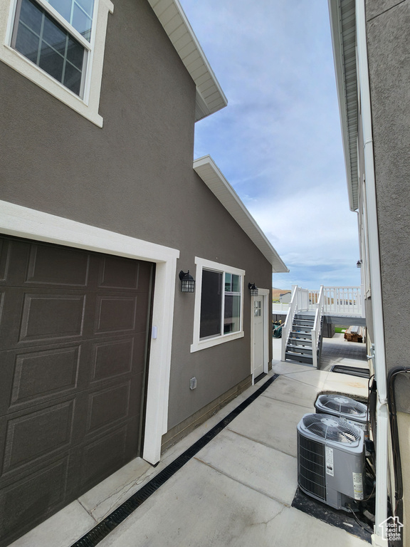 Property entrance featuring stucco siding and central AC unit