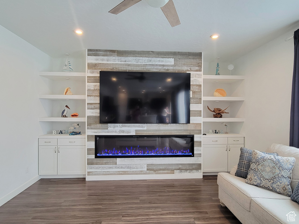 Living area with dark wood-style flooring, a large fireplace, ceiling fan, baseboards, and recessed lighting