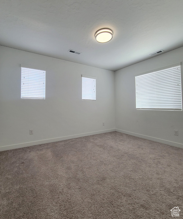 Empty room featuring baseboards and carpet floors