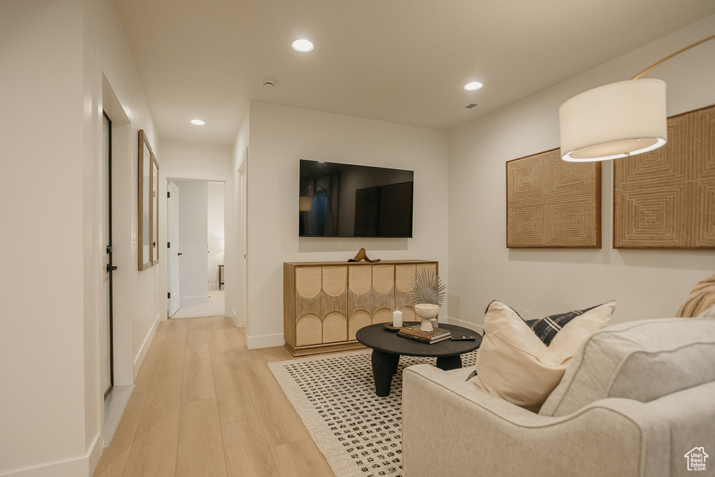 Living area with light wood-style flooring, recessed lighting, and baseboards