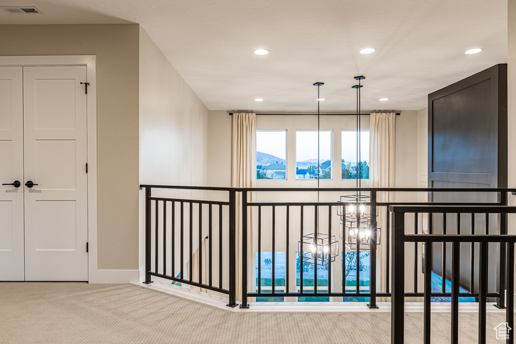 Corridor featuring carpet, recessed lighting, a chandelier, a mountain view, and baseboards