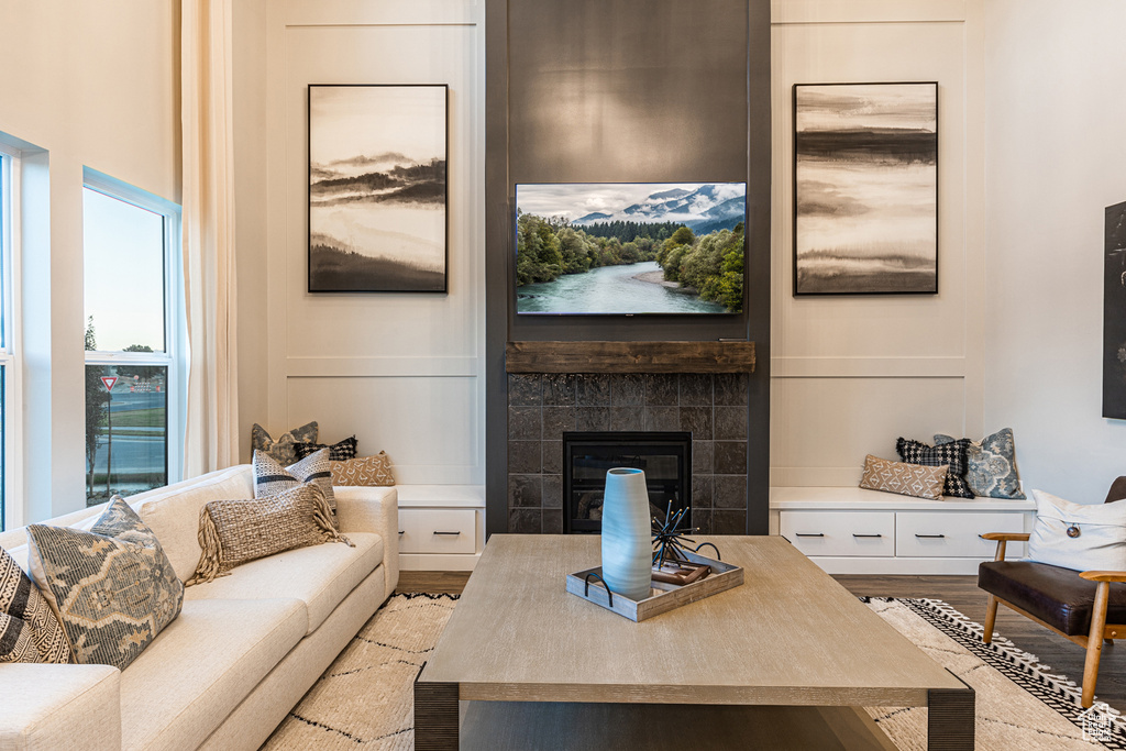 Living room featuring light wood-style floors and a tiled fireplace