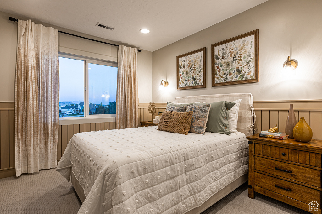 Bedroom featuring carpet flooring, a wainscoted wall, a decorative wall, and recessed lighting
