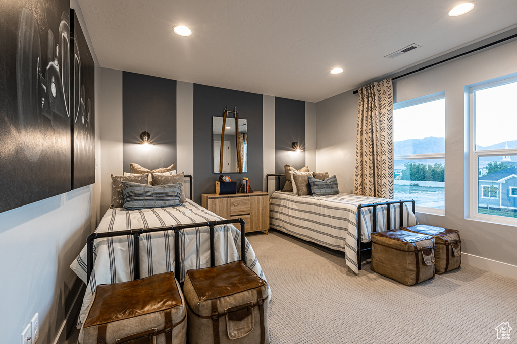 Bedroom featuring light colored carpet, recessed lighting, multiple windows, and baseboards