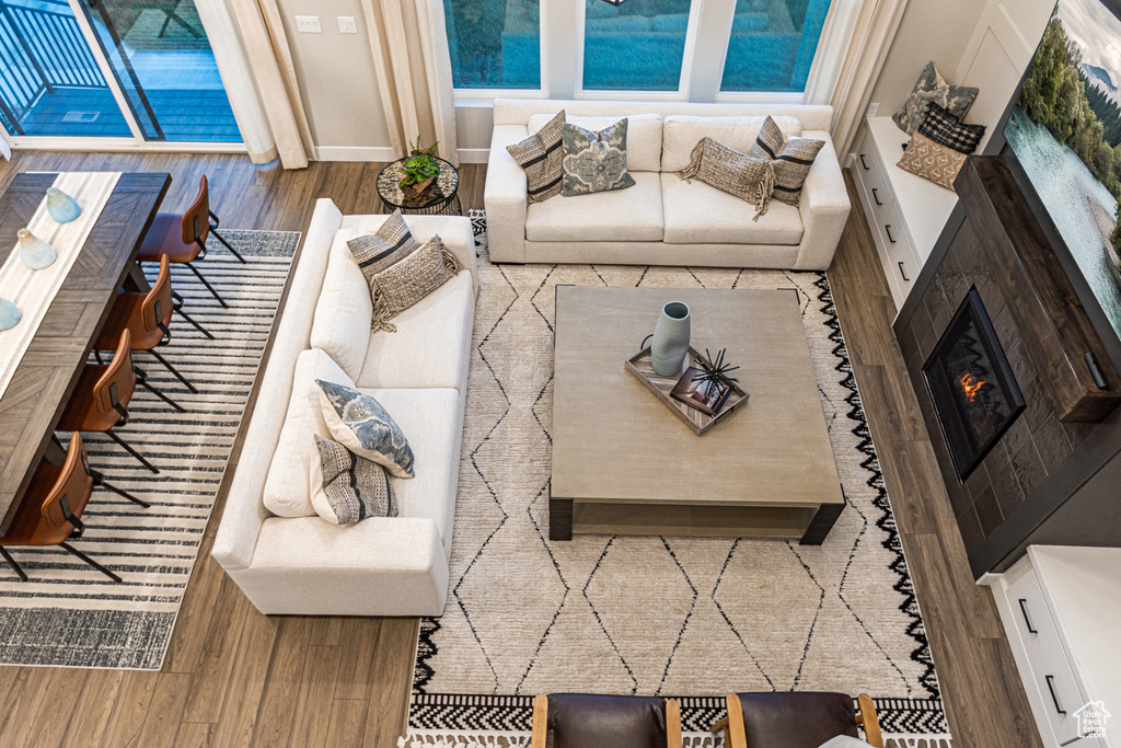 Living room with wood finished floors and a lit fireplace