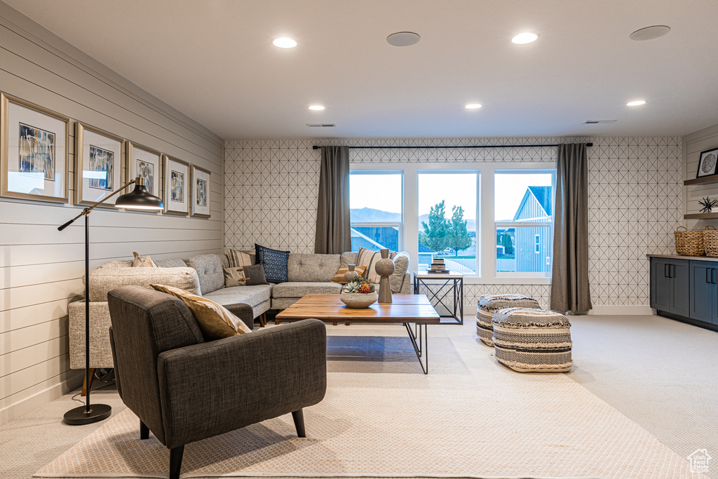 Carpeted living area with recessed lighting and wallpapered walls
