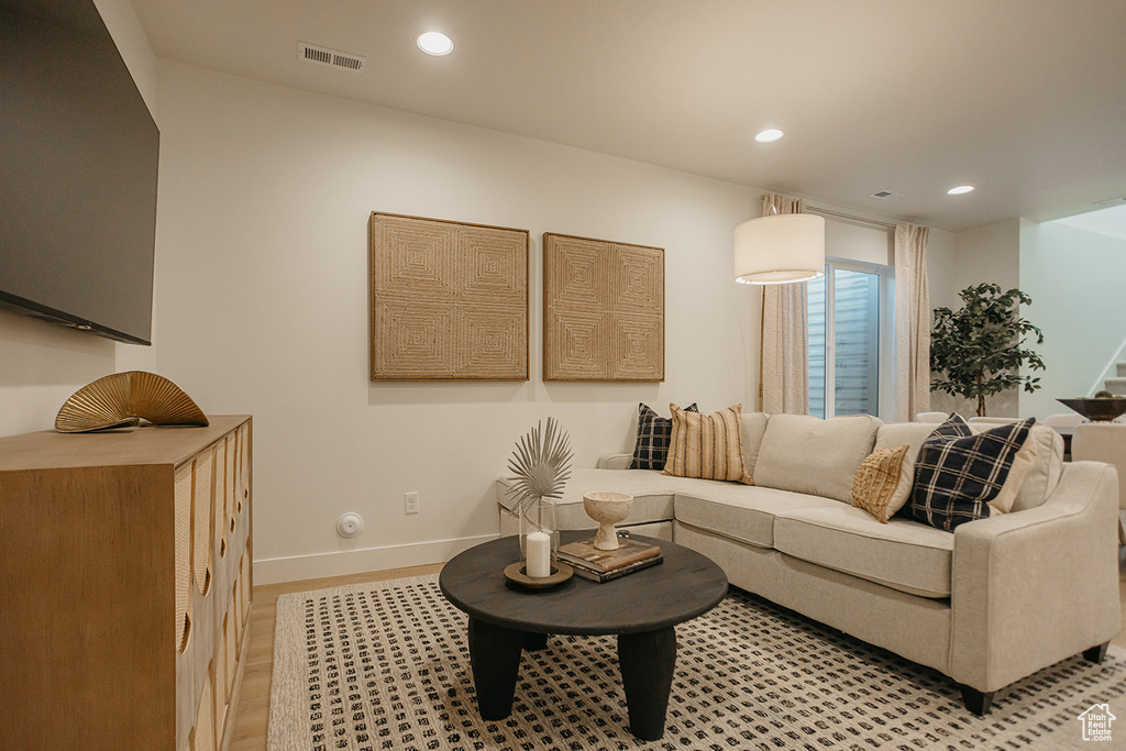 Living room with stairway, recessed lighting, light wood-style floors, and baseboards