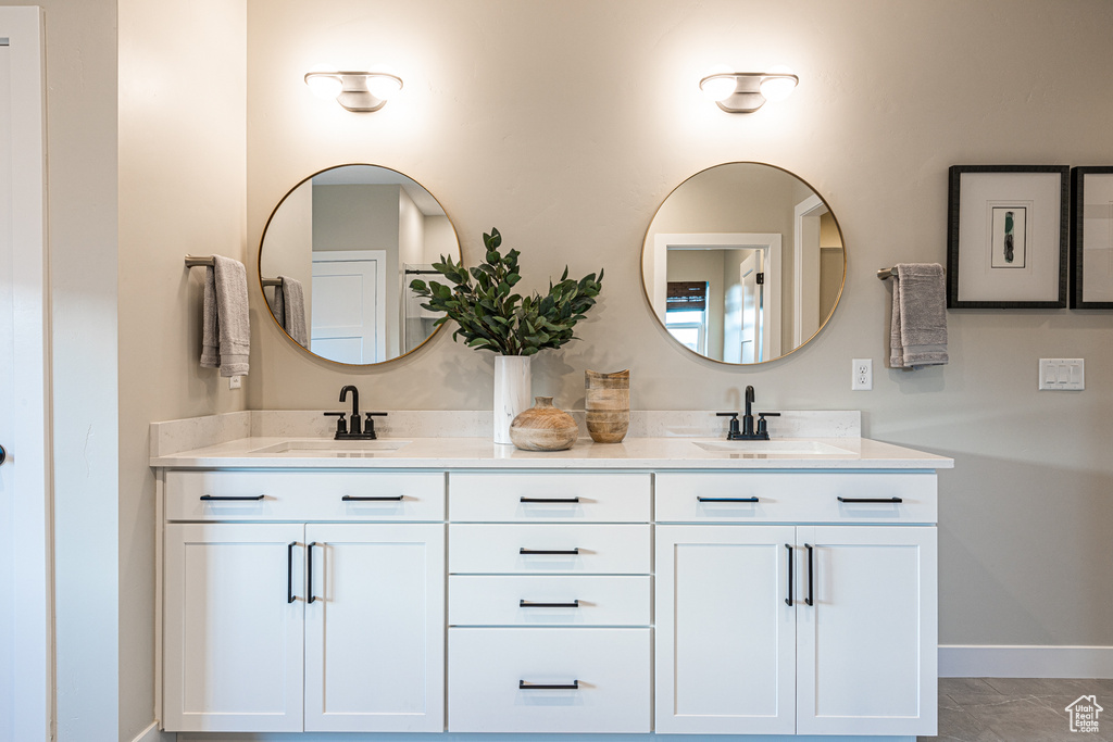 Full bath with double vanity and baseboards