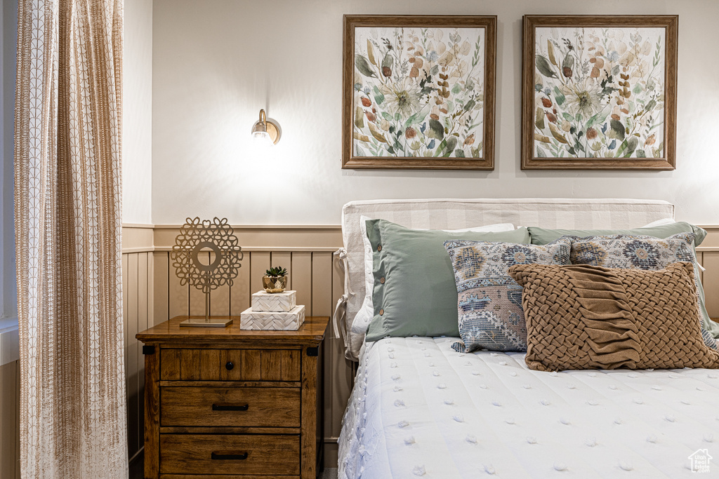 Bedroom with a wainscoted wall and a decorative wall