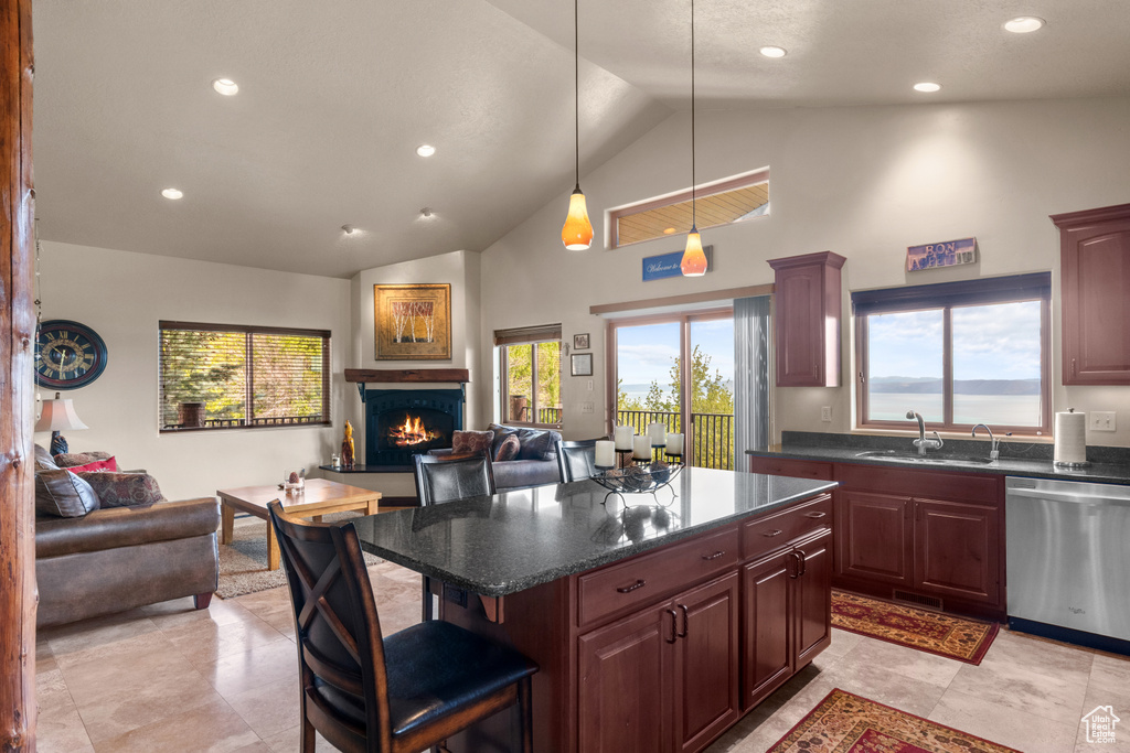 Kitchen featuring dishwasher, open floor plan, a sink, a warm lit fireplace, and high vaulted ceiling