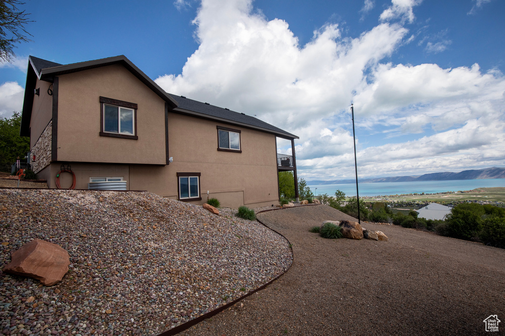 View of side of property featuring stucco siding and a water view