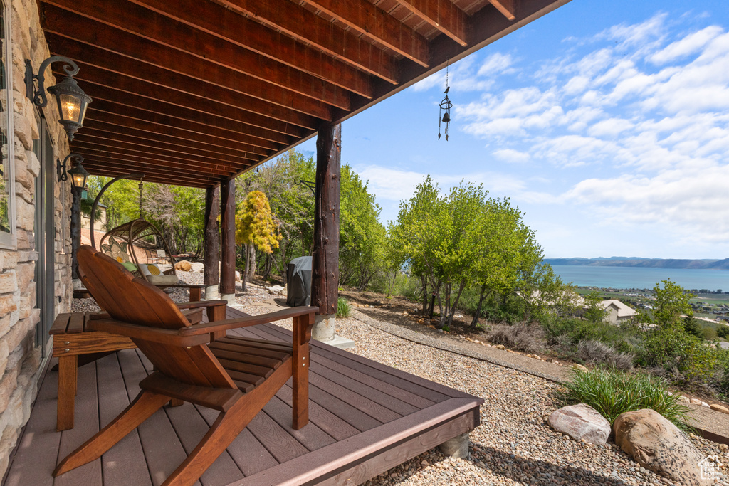 Wooden terrace with a water view and a patio area