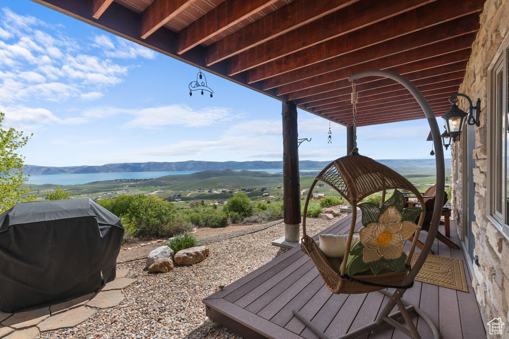 Wooden terrace with area for grilling and a water and mountain view