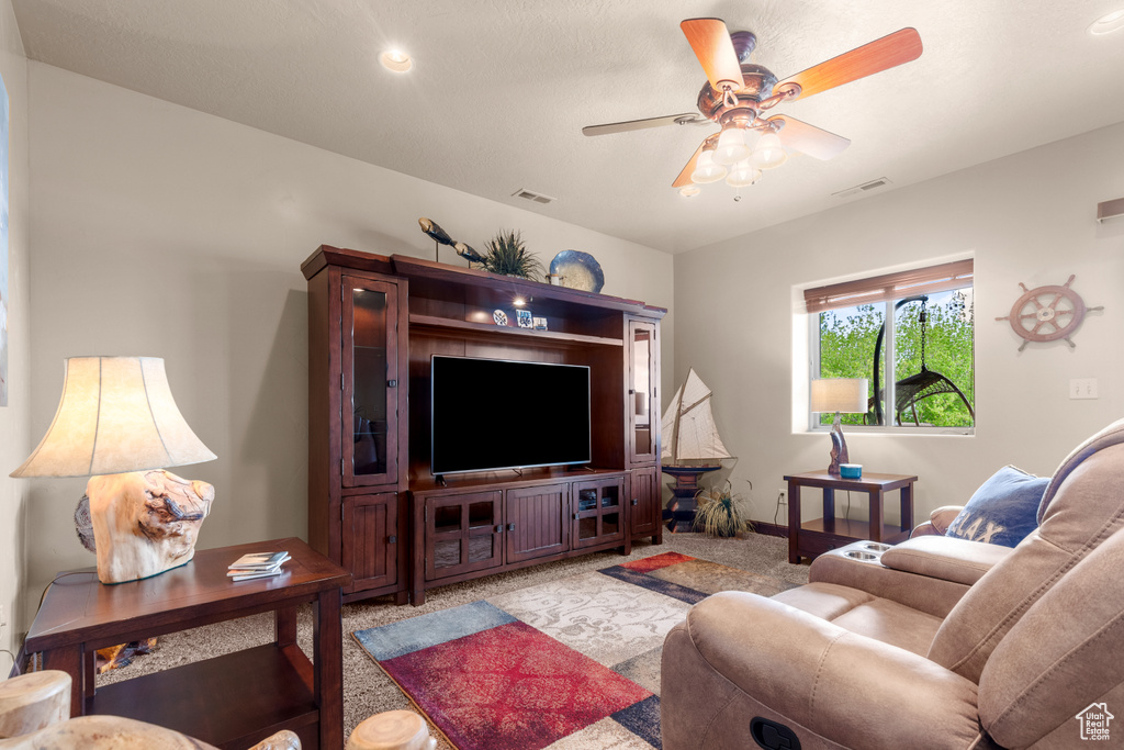 Living area featuring a ceiling fan and light colored carpet