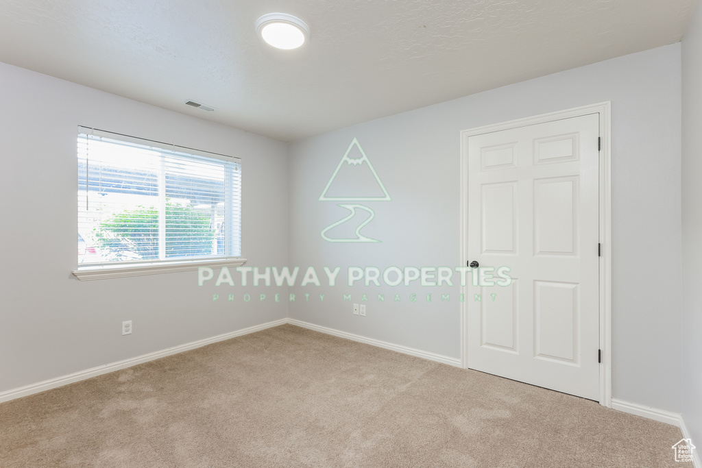 Carpeted spare room with baseboards