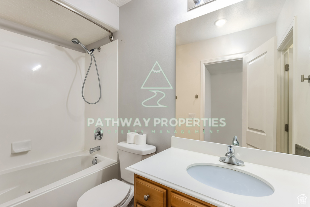 Bathroom featuring  shower combination, vanity, and toilet