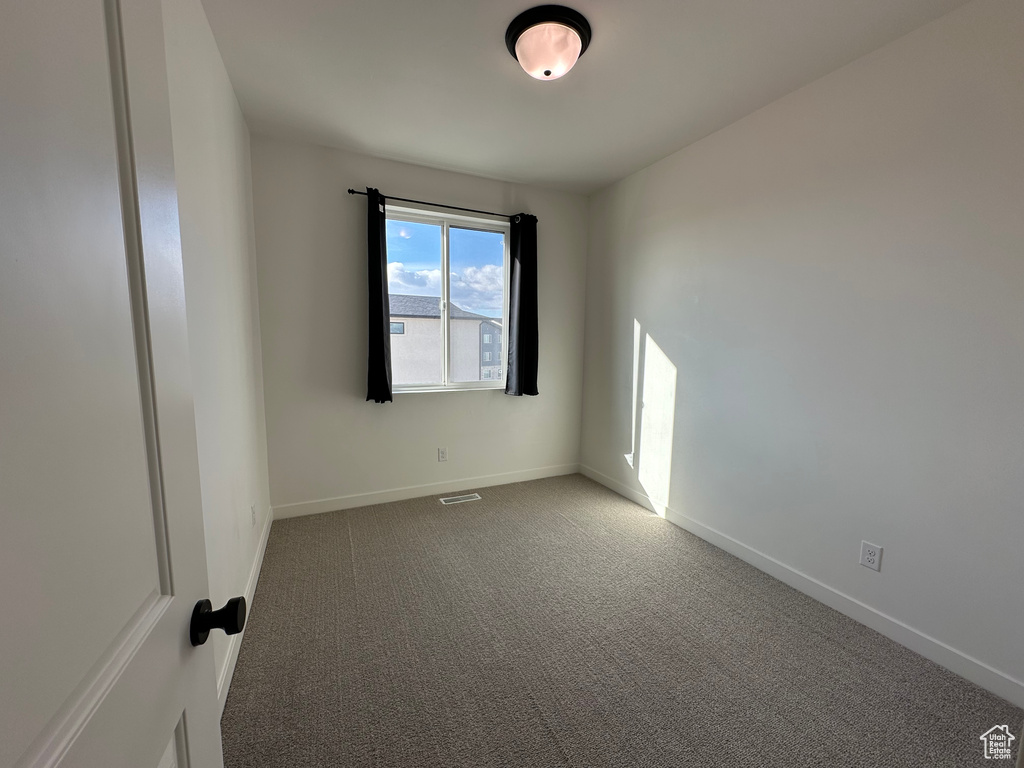 Spare room with baseboards and carpet flooring