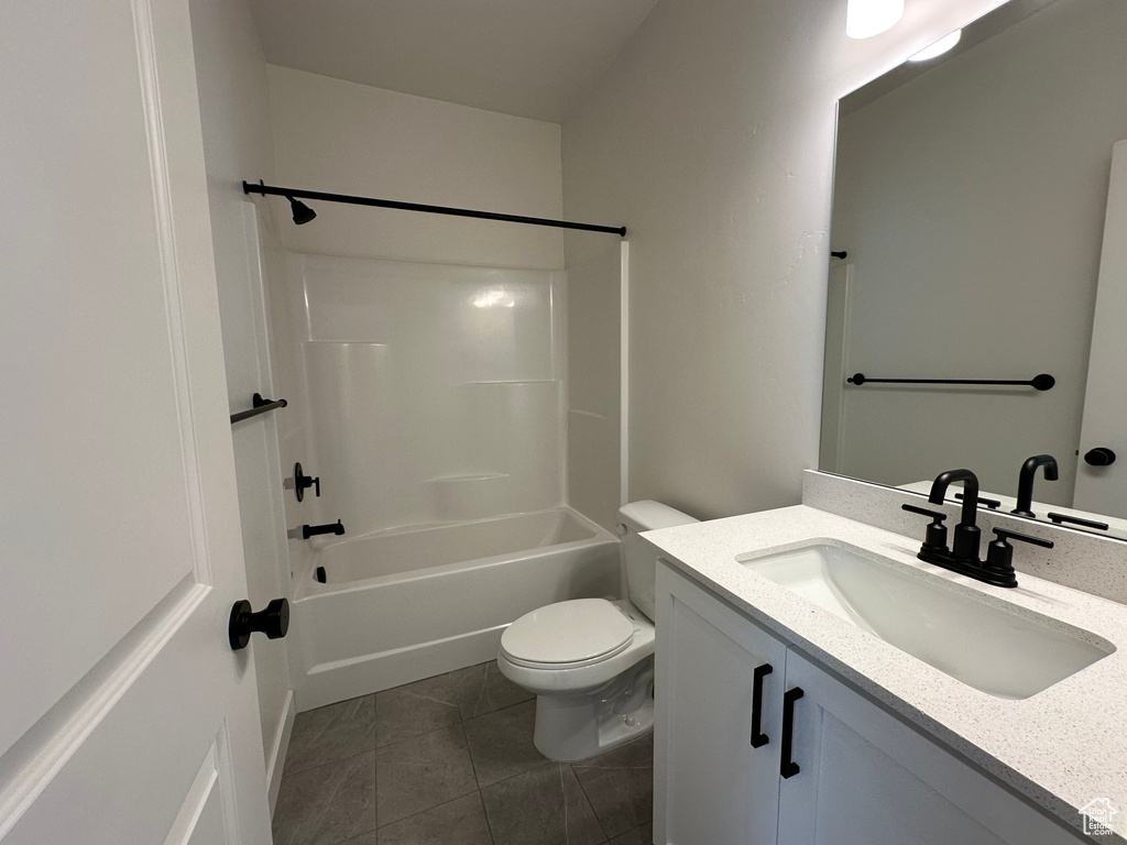 Full bathroom featuring toilet, tile patterned floors, vanity, and bathtub / shower combination