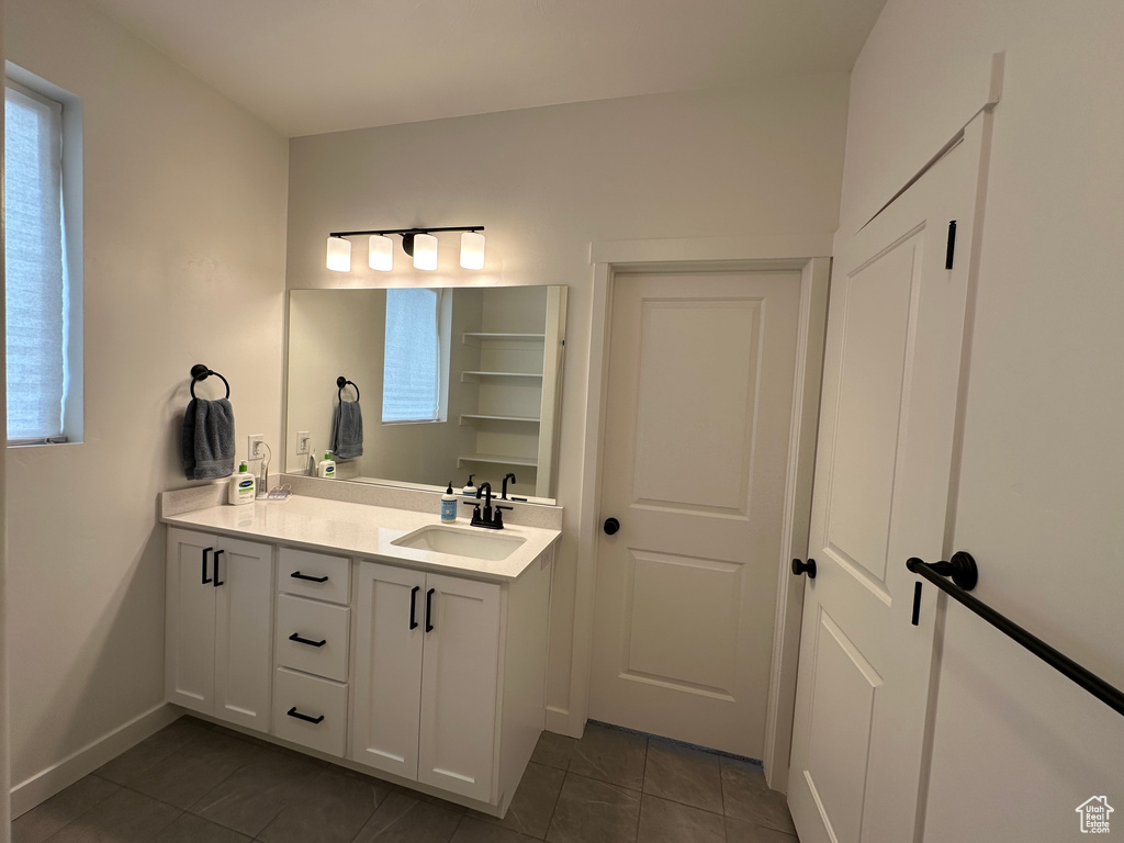 Bathroom with tile patterned flooring, vanity, and baseboards
