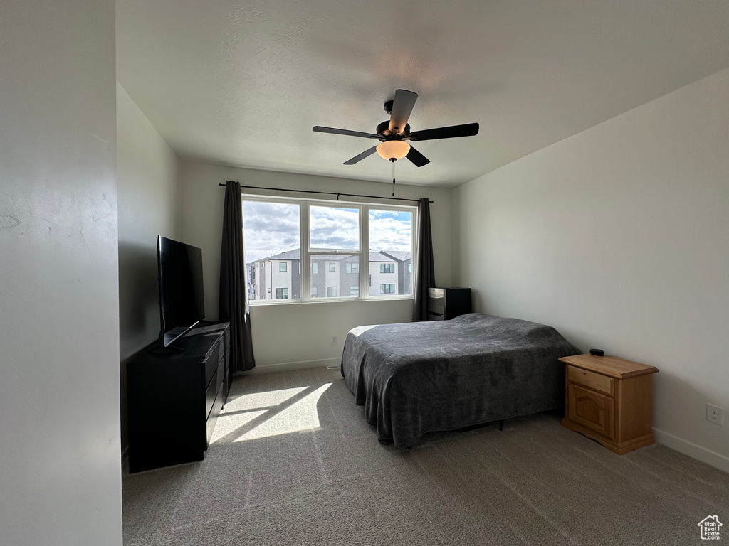 Bedroom with light carpet, baseboards, and a ceiling fan
