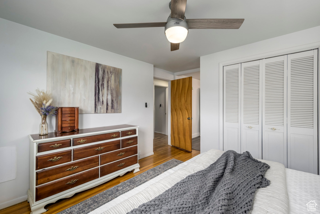 Bedroom featuring a closet, wood finished floors, ceiling fan, and baseboards