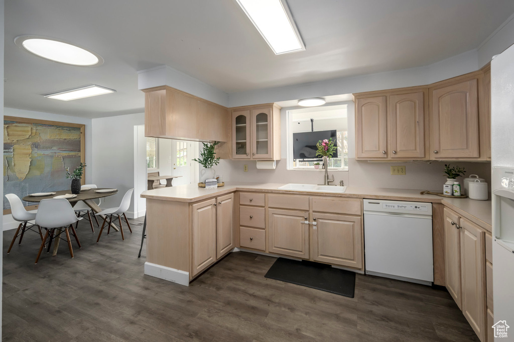 Kitchen with dishwasher, a sink, light brown cabinetry, and light countertops