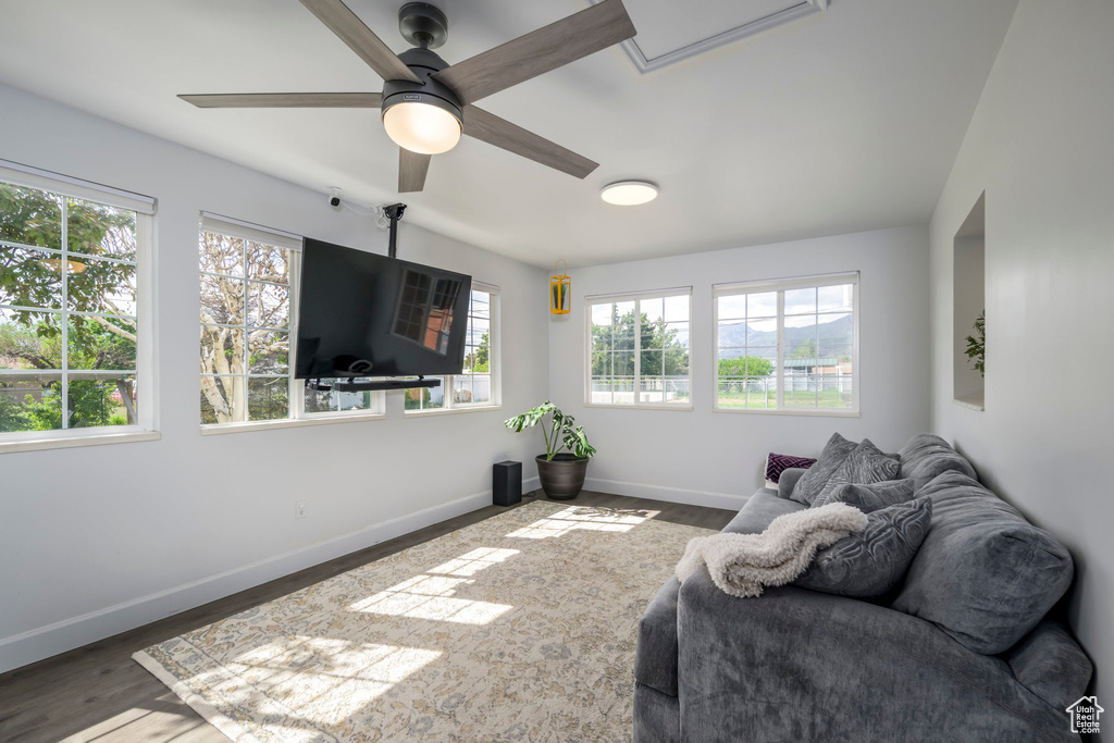 Living room featuring ceiling fan, baseboards, and wood finished floors